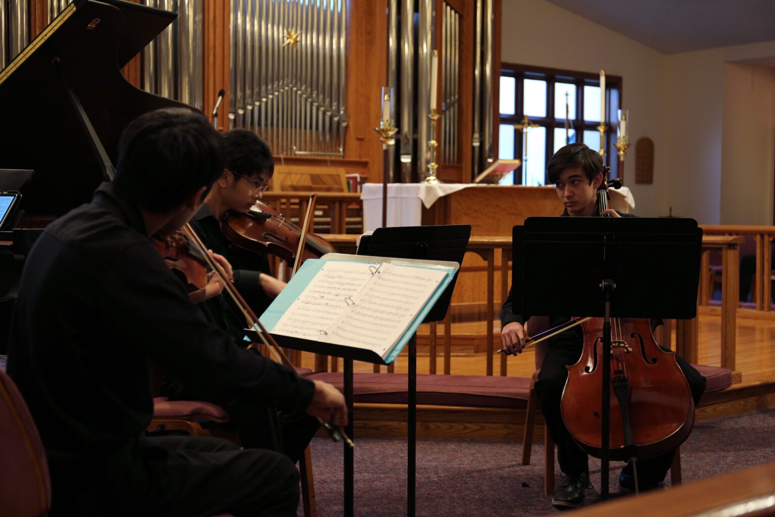 NCCMI students make eye contact while playing in a piano quartet